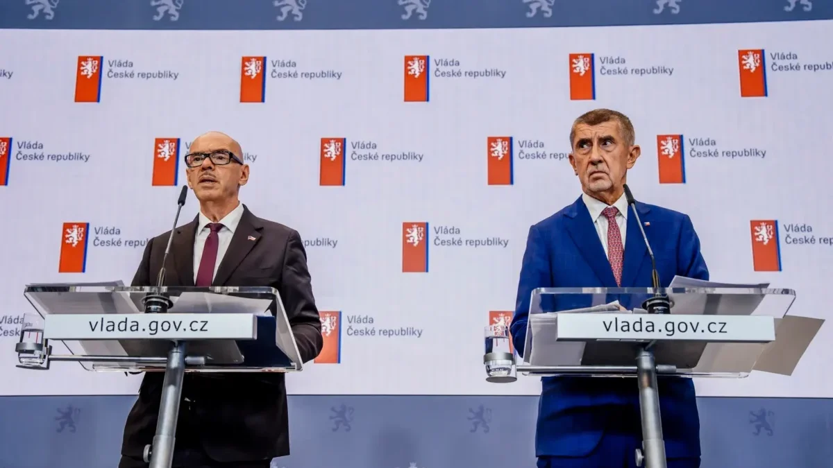 Dva muži v oblecích u pultíků s mikrofony