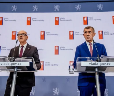 Dva muži v oblecích u pultíků s mikrofony