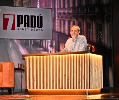 Honza Dědek sedí za stolem.