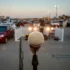 Close-up of a microphone on a stand in the foreground with a blurred outdoor parking lot full of cars in the background.