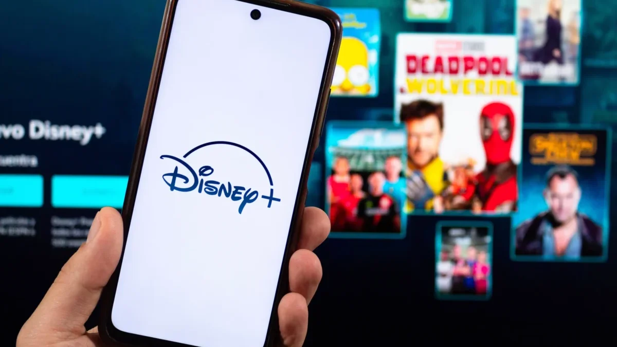 Člověk v ruce drží telefon s Disney+.