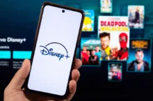Člověk v ruce drží telefon s Disney+.