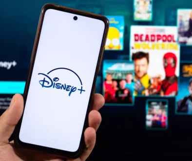 Člověk v ruce drží telefon s Disney+.