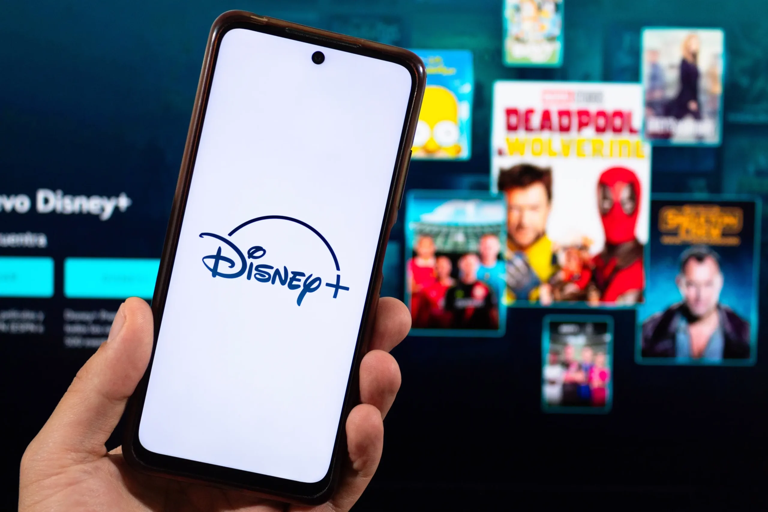 Člověk v ruce drží telefon s Disney+.
