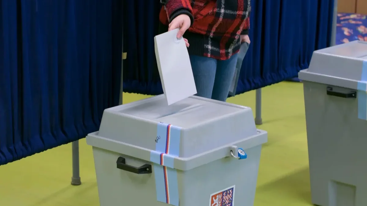 muž vhazuje hlasovací lístek do volební urny