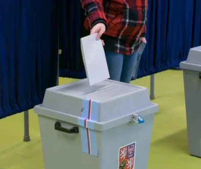 muž vhazuje hlasovací lístek do volební urny