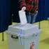 muž vhazuje hlasovací lístek do volební urny