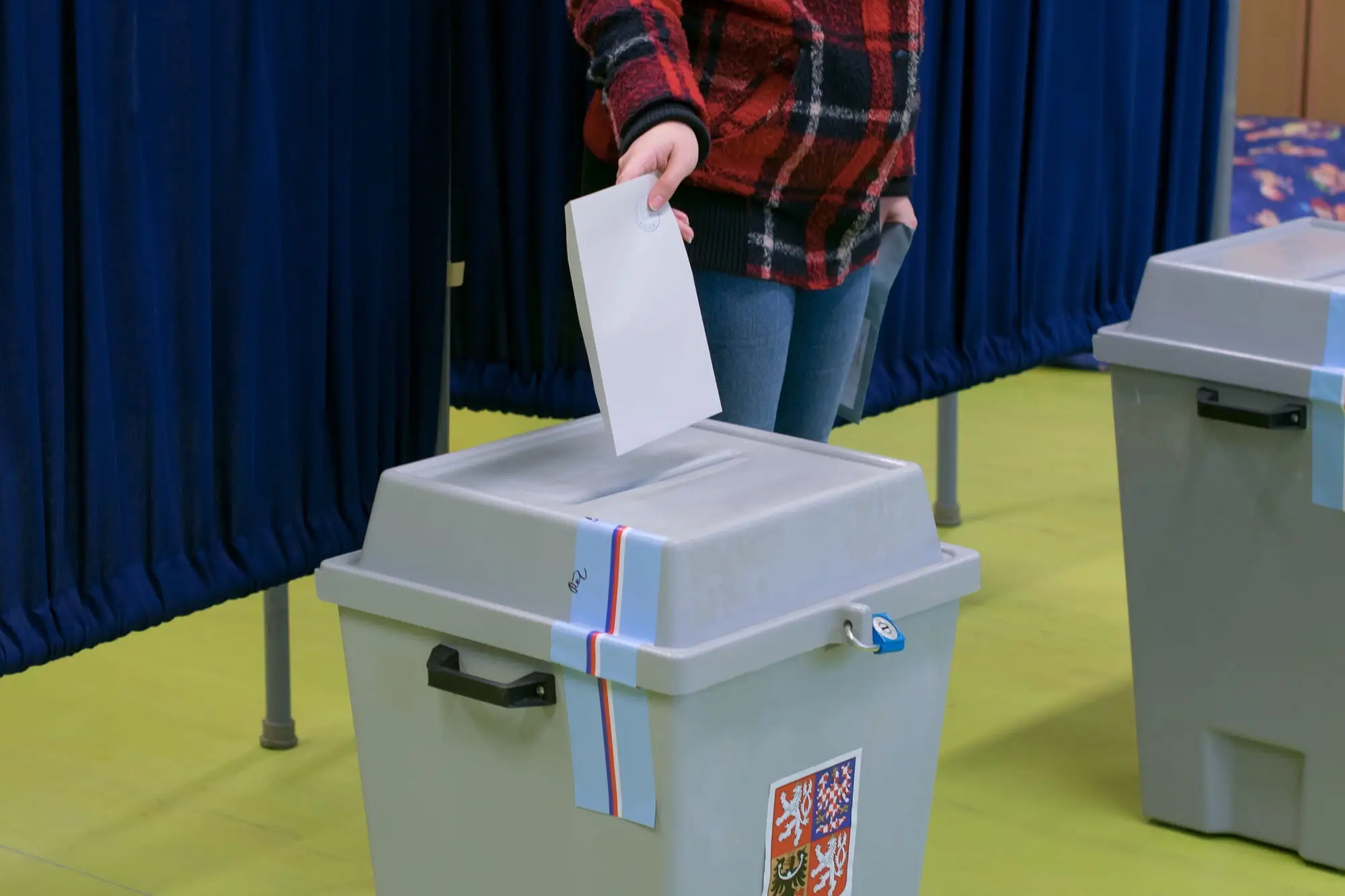 muž vhazuje hlasovací lístek do volební urny