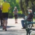 důchodce s rouškou sedící na lavičce