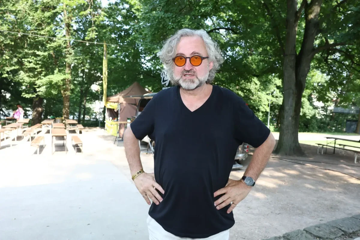 Jan Hřebejk stojí v parku.