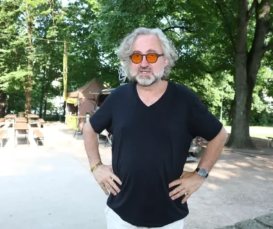 Jan Hřebejk stojí v parku.