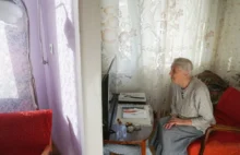 Stará žena kouká z gauče na tv