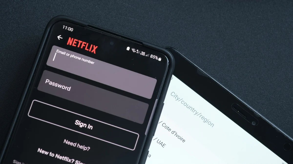 shutterstock_2311209095 1 | TVGURU.cz Smartphone showing Netflix login screen with fields for Email or phone number and Password, and Sign In button on a dark background.