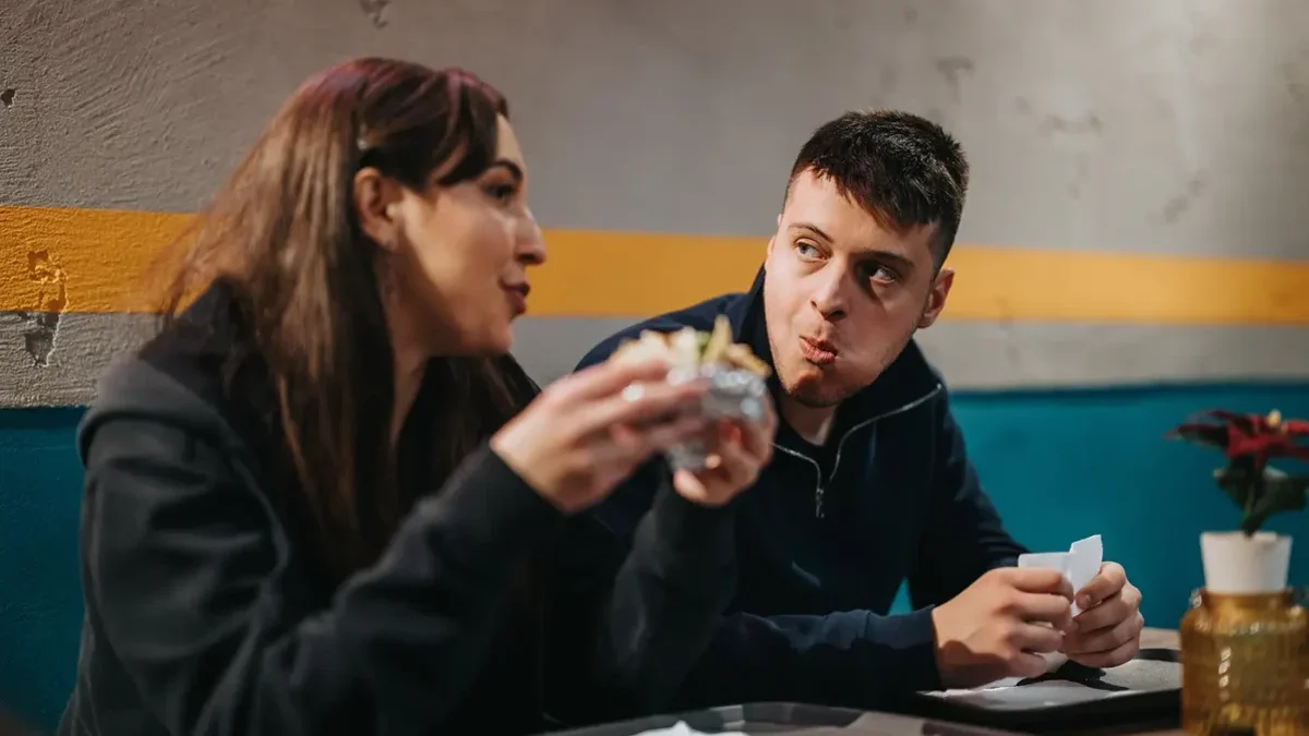 Muž a žena sedí u stolu a jedí spolu
