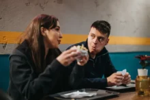 Muž a žena sedí u stolu a jedí spolu