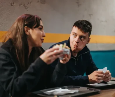 Muž a žena sedí u stolu a jedí spolu