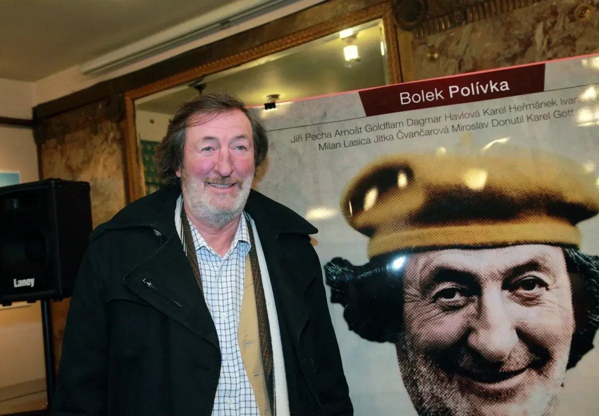 Bolek Polívka stojí před svým plakátem.