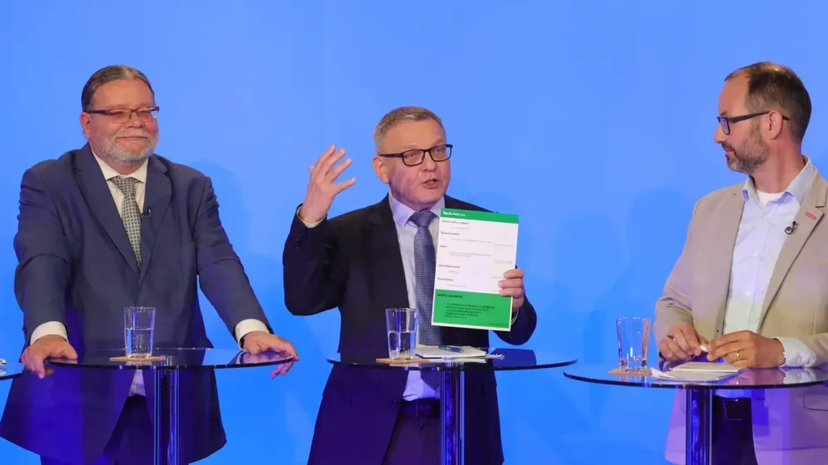 Tři muži v oblecích u moderovacích pultíků