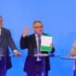 Tři muži v oblecích u moderovacích pultíků