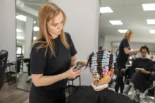 Kadeřnice své zákaznici natáčí vlasy na natáčky