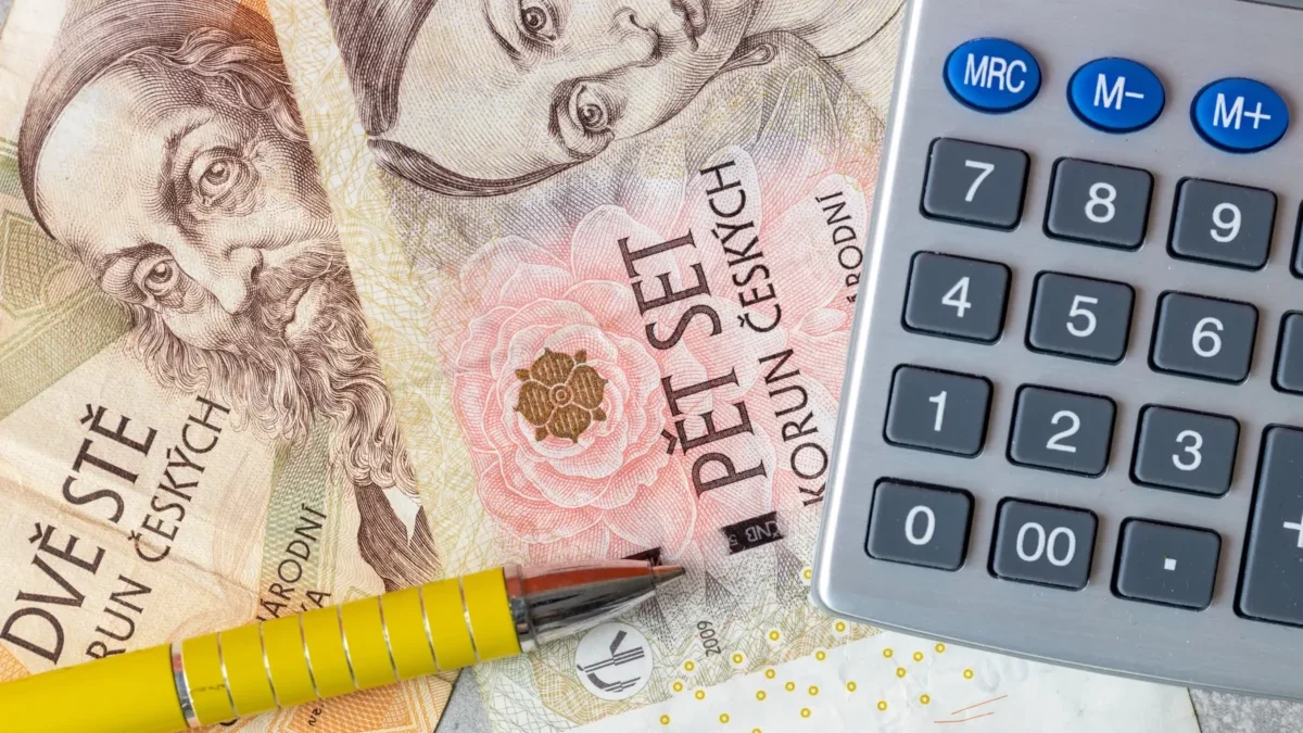 Close-up of euro banknotes with a calculator and yellow pencils, suggesting financial calculations.