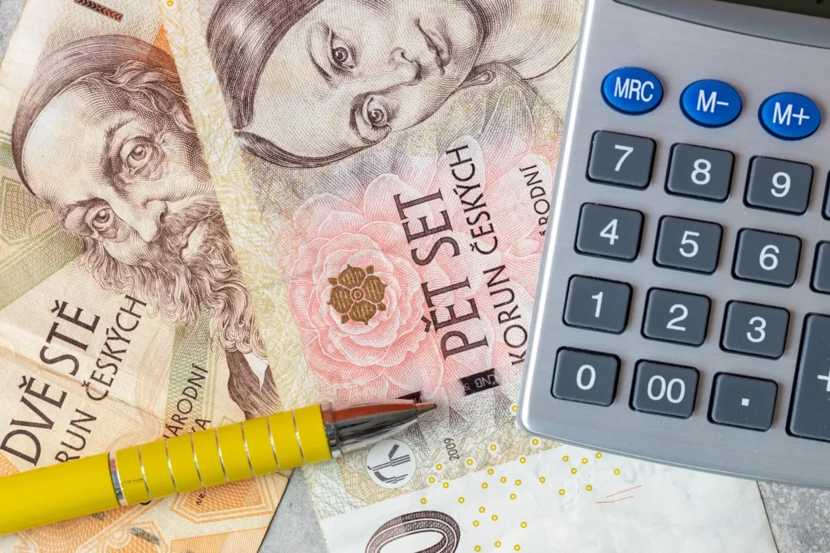 Close-up of euro banknotes with a calculator and yellow pencils, suggesting financial calculations.