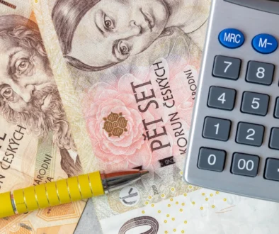 Close-up of euro banknotes with a calculator and yellow pencils, suggesting financial calculations.