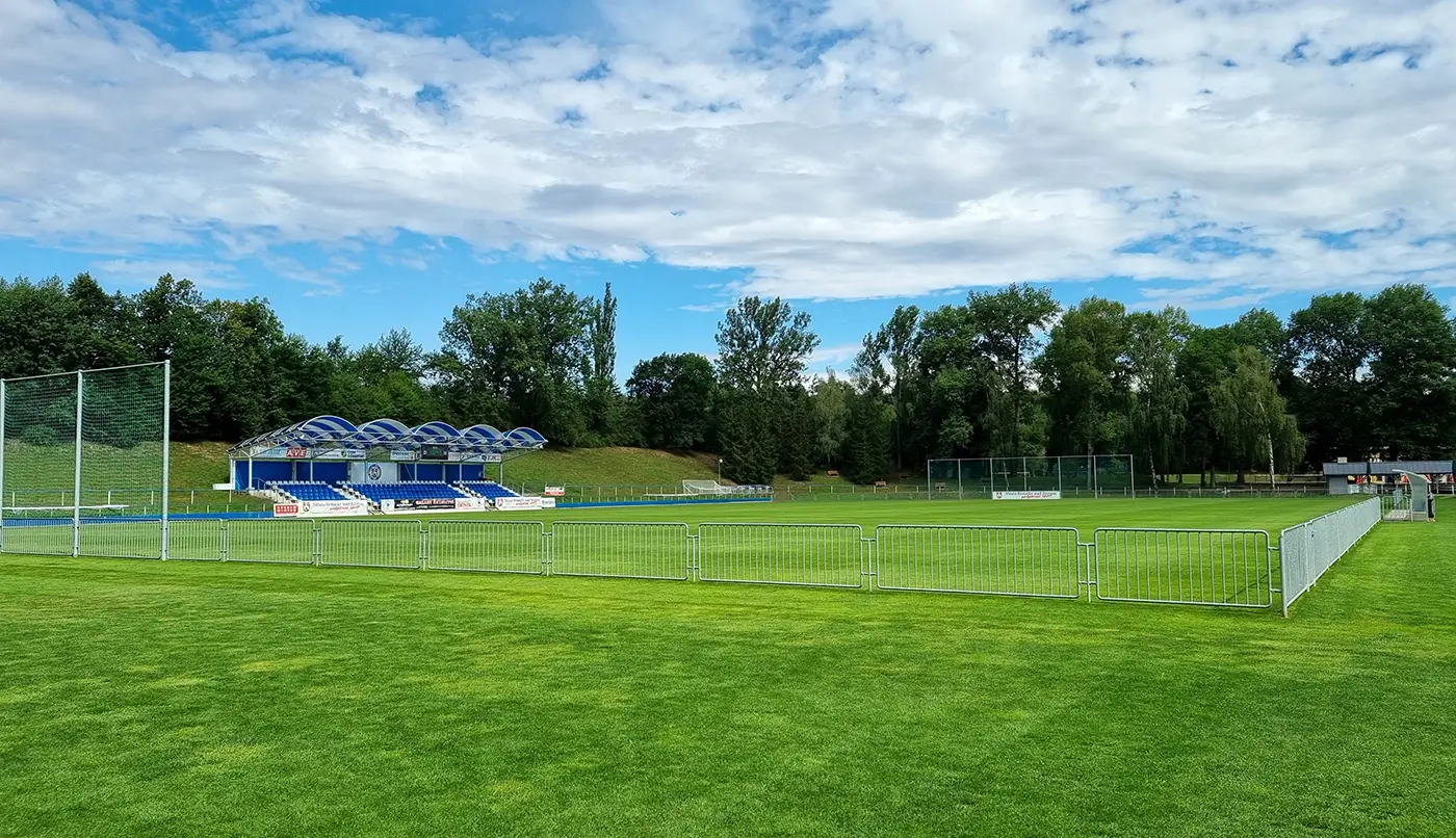 shutterstock_2823369255 | TVGURU.cz Fotbalové hřiště s udržovaným zeleným trávníkem, brankou a lavičkami
