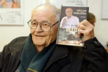 Václav Vorlíček v ruce drží knihu.