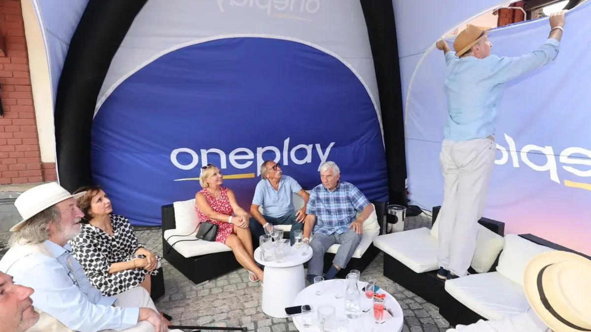 stan s nápisem Oneplay a lidé pod ním