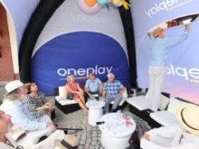 stan s nápisem Oneplay a lidé pod ním