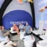 stan s nápisem Oneplay a lidé pod ním