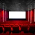 Red-walled cinema interior with a large white screen at the front and red seating throughout the auditorium.