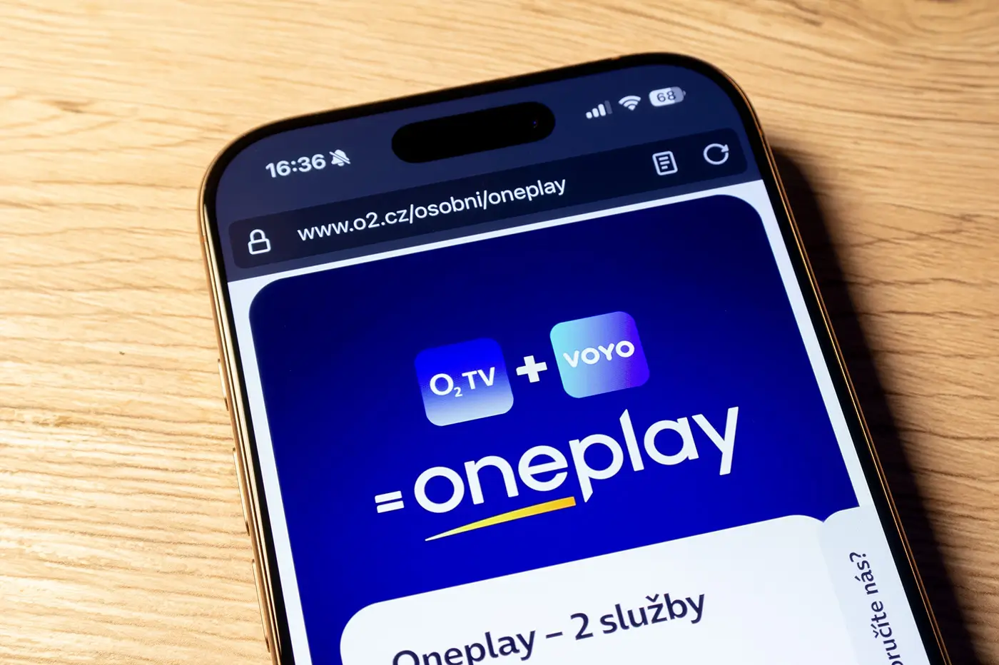 shutterstock_2591175567 | TVGURU.cz Mobilní telefon ležící na stole zobrazuje logo streamovací platformy a mobilního operátora