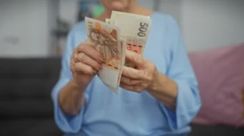 Seniorka počítá bankovky.
