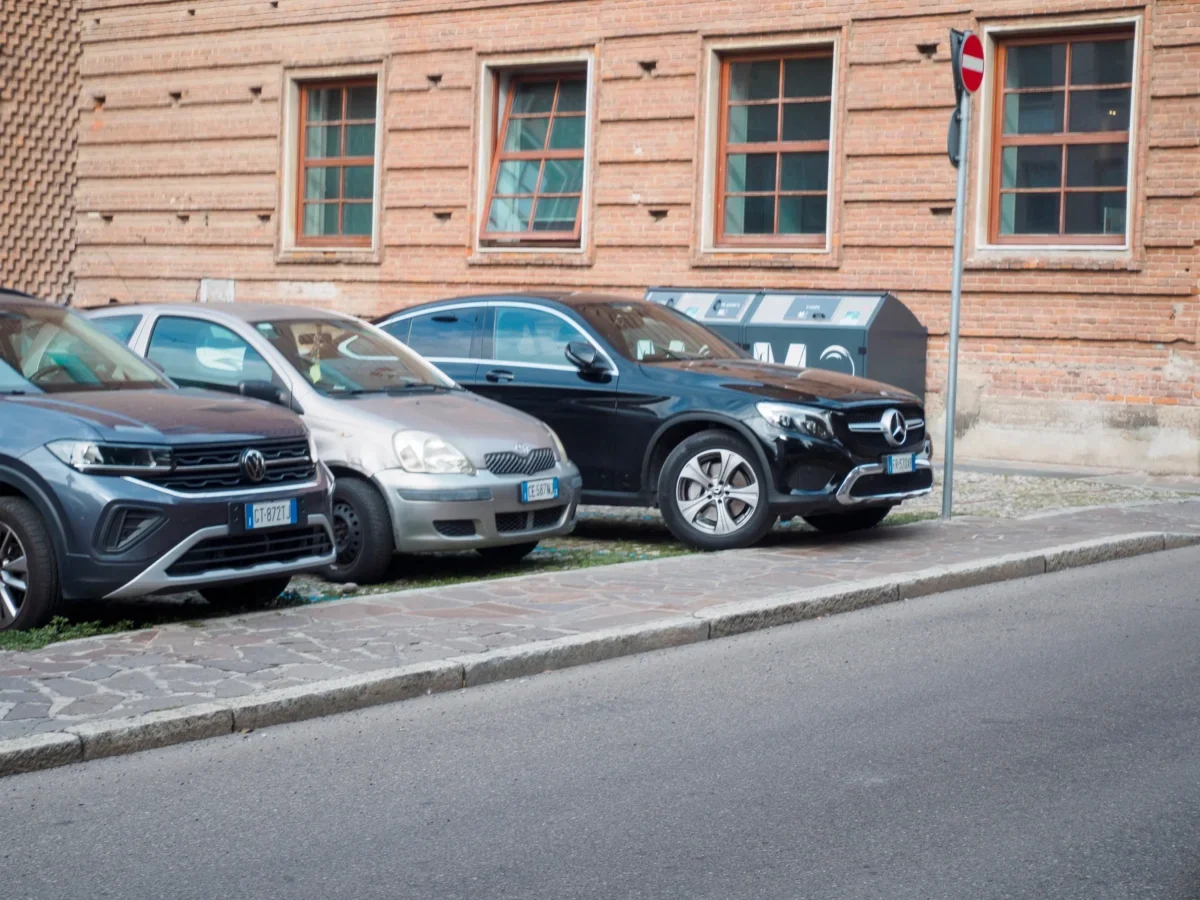 Vedle sebe stojí zaparkovaná tři auta na ulici.