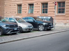 Vedle sebe stojí zaparkovaná tři auta na ulici.