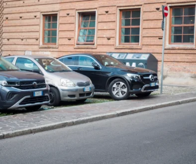 Vedle sebe stojí zaparkovaná tři auta na ulici.