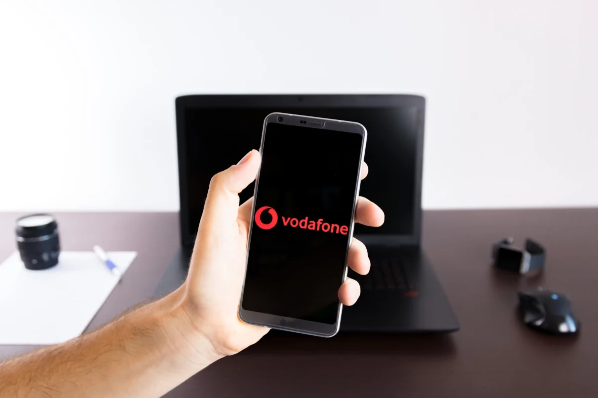 Službu lze nainstalovat také do telefonu. Zdroj: Shutterstock | TVGURU.cz Člověk držící telefon s aplikací Vodafone