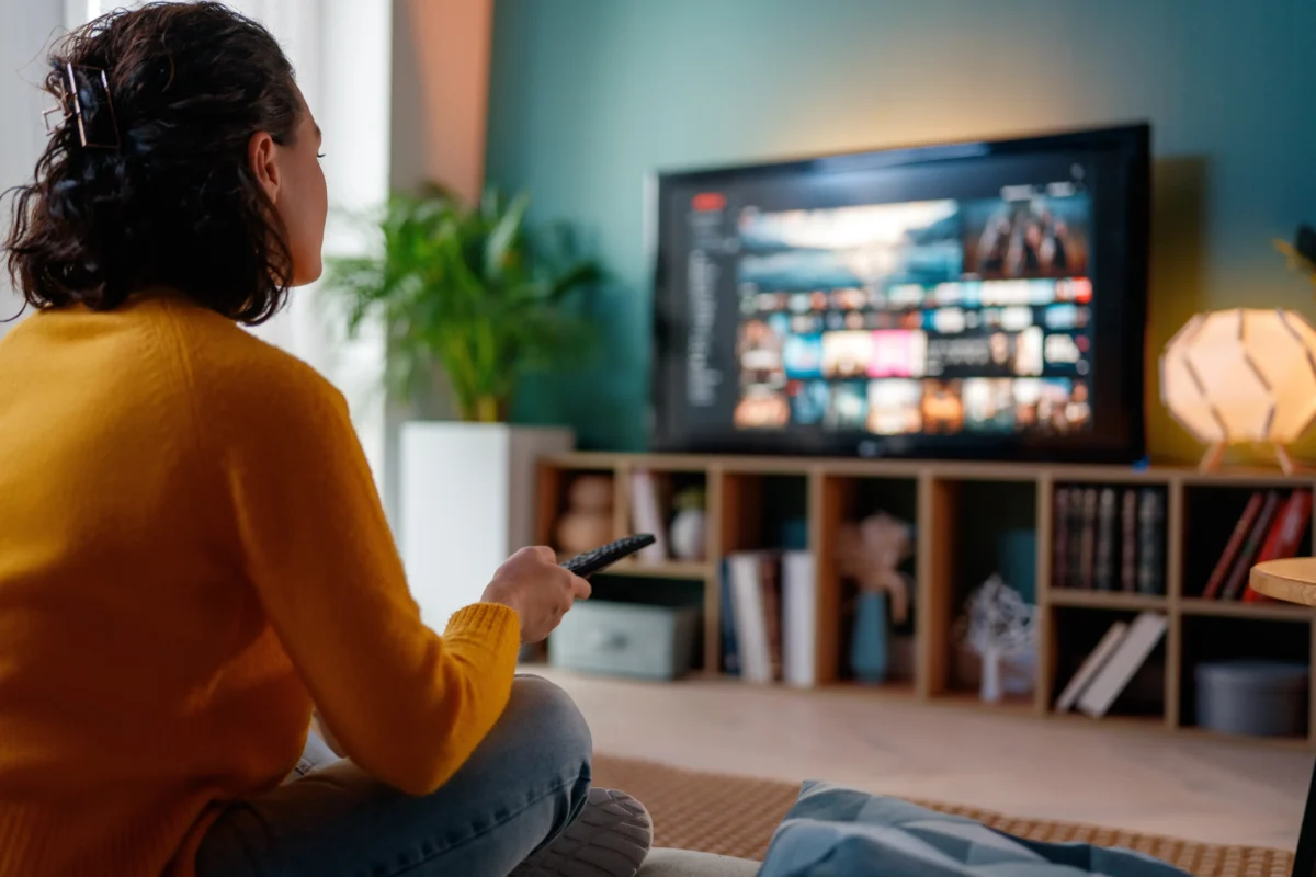 Soutěž už je vysílaná dlouhých pět let. Zdroj: Shutterstock | TVGURU.cz Žena sedící u televize s ovladačem v ruce