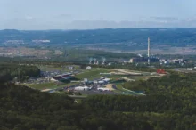Letecký pohled na severočeské město a autodrom obklopený zelenými lesy