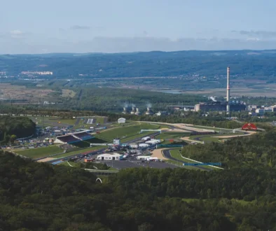 Letecký pohled na severočeské město a autodrom obklopený zelenými lesy