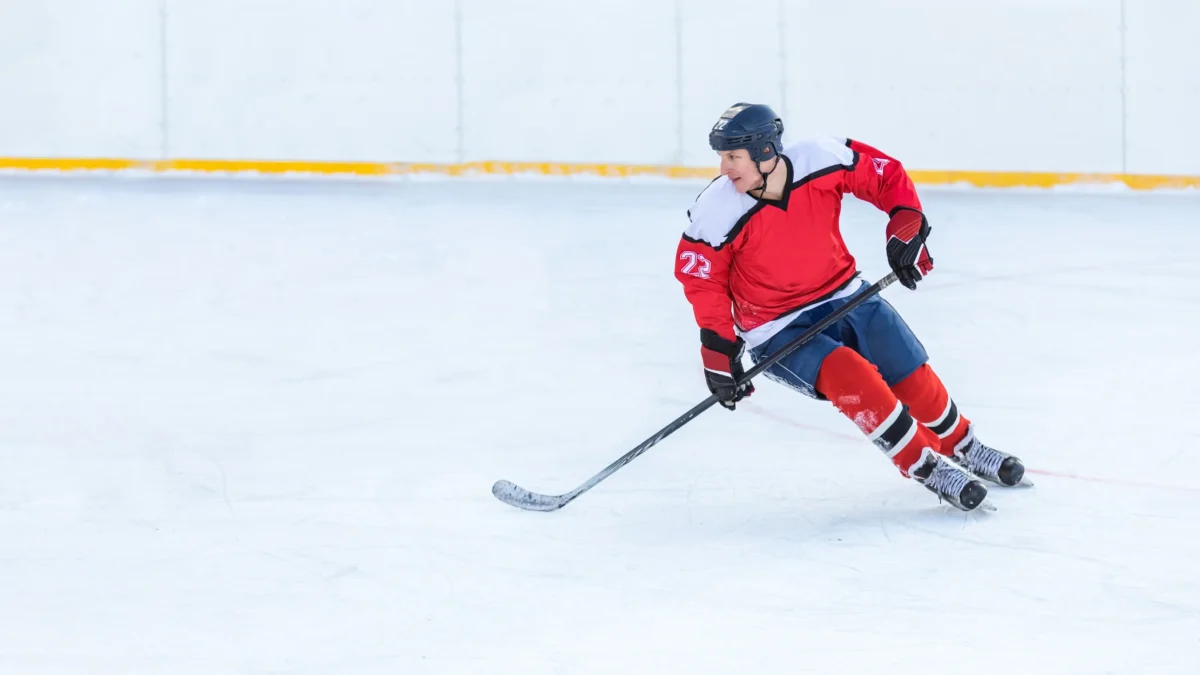 Některé zápasy nabízí i ČT Sport a Prima Sport. Zdroj: Shutterstock | TVGURU.cz Hokejista v červeném dresu na ledě