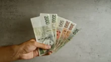 6 tisíc korun v českých bankovkách drží člověk v ruce.