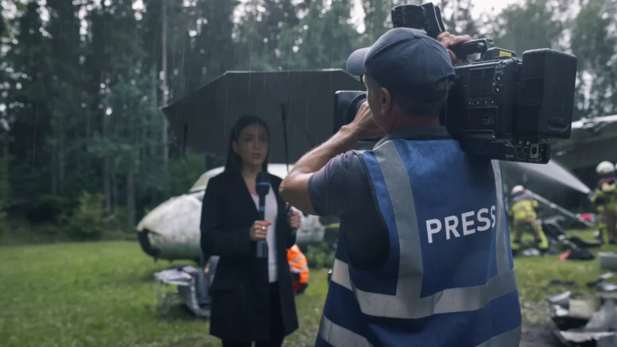 Žena před zpravodajskou kamerou v dešti