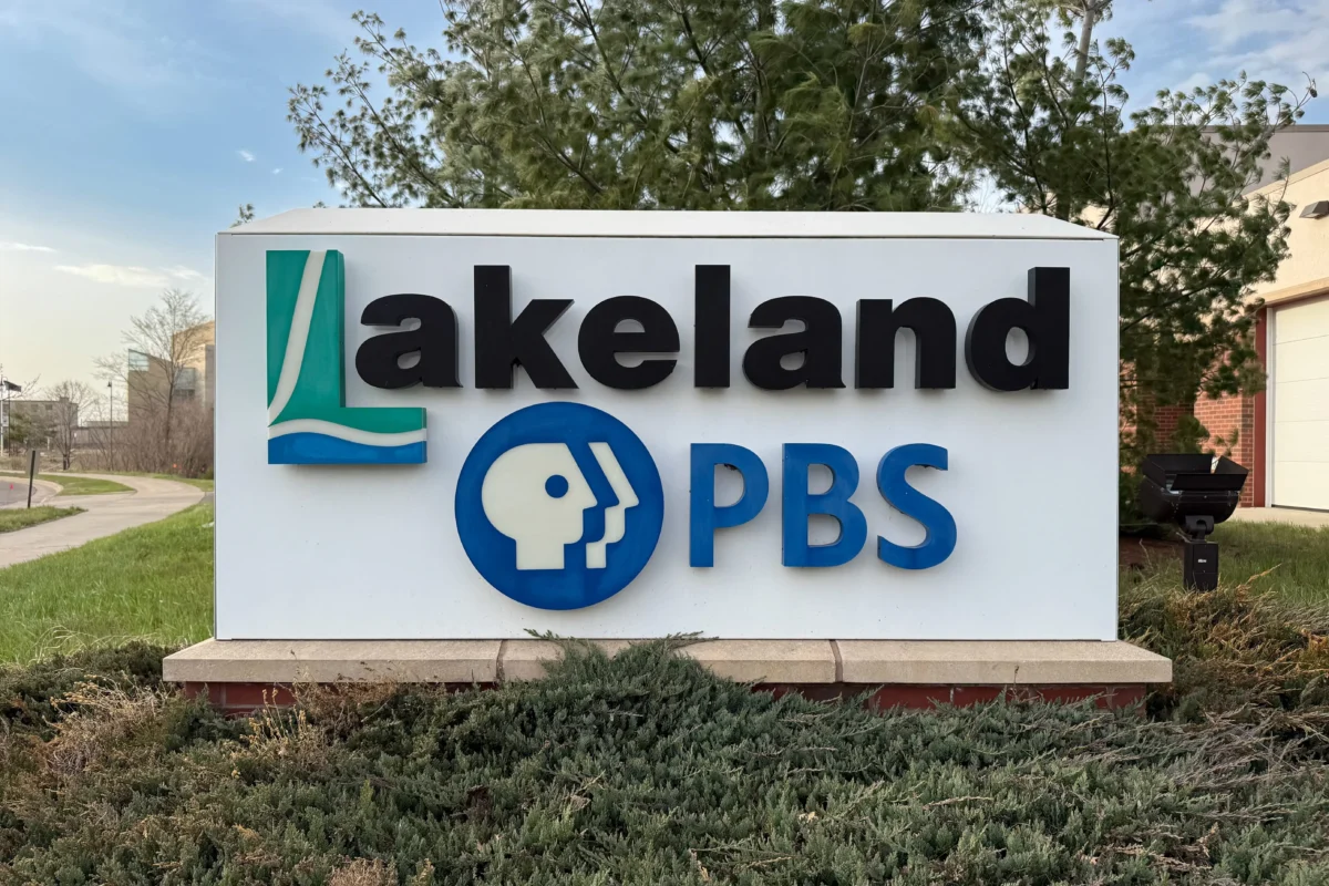 shutterstock_2839197515 1 | TVGURU.cz Outdoor Lakeland sign featuring a green abstract logo, large black'Lakeland' lettering, and a blue PBS emblem below.