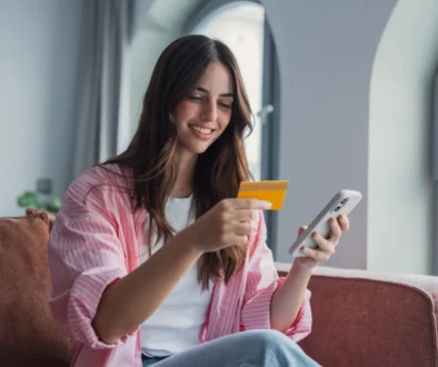 Veselá dívka s platební kartou a telefonem