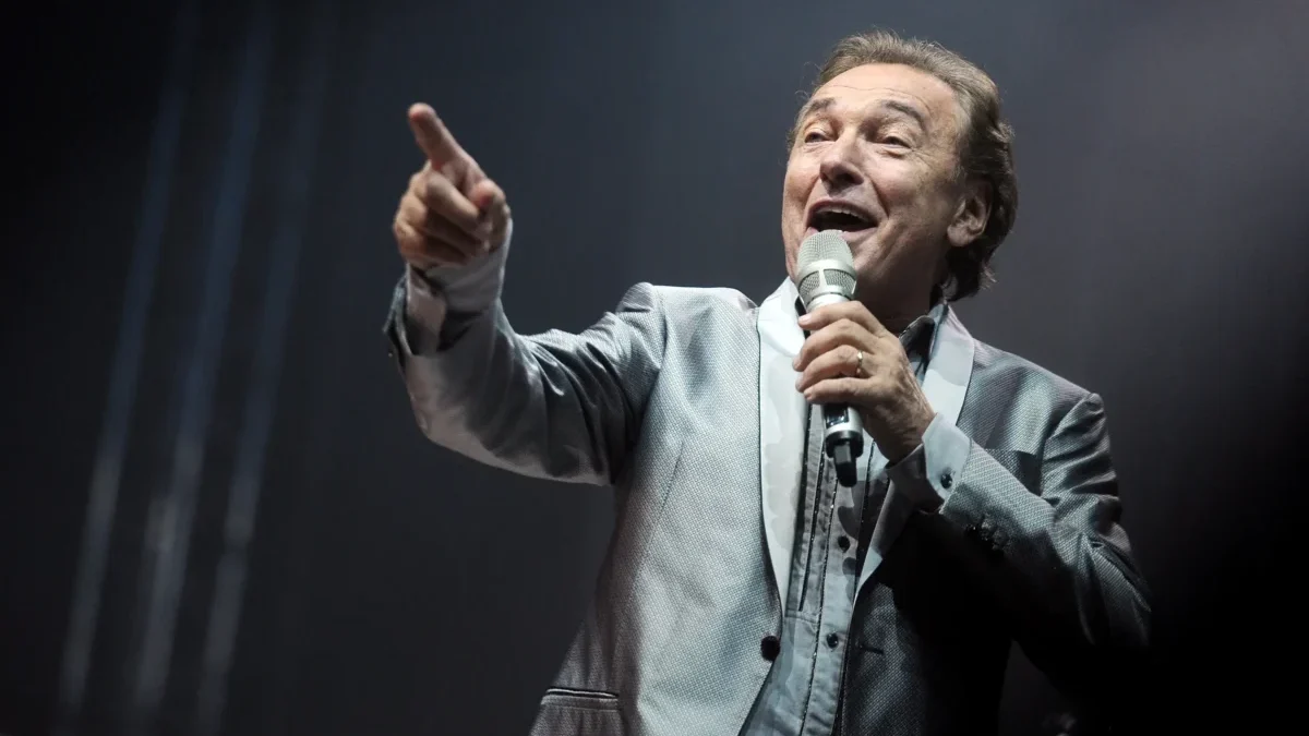 Karel Gott zpívá s mikrofonem v ruce.