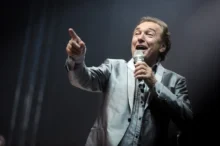 Karel Gott zpívá s mikrofonem v ruce.