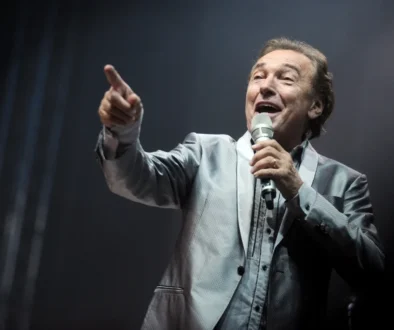 Karel Gott zpívá s mikrofonem v ruce.
